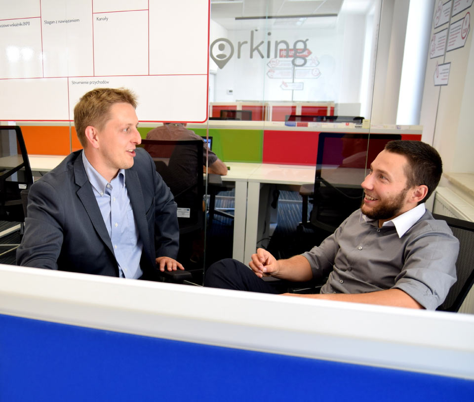 Phillip Poynton conversing with male student in office enviroment